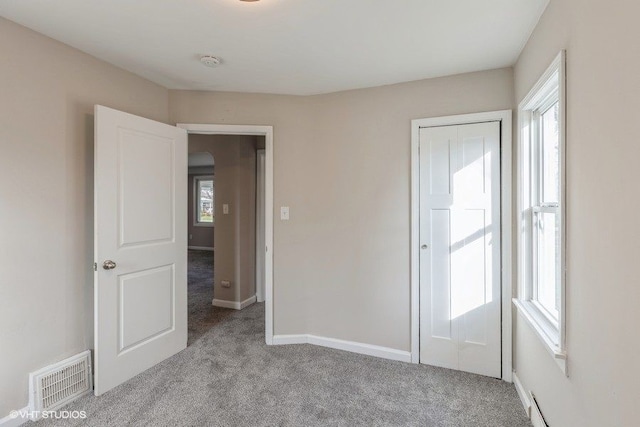 spare room with light carpet and plenty of natural light