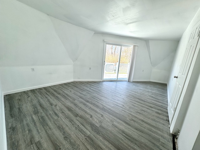 additional living space featuring dark hardwood / wood-style floors and lofted ceiling