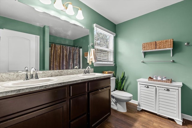 bathroom with hardwood / wood-style floors, vanity, and toilet