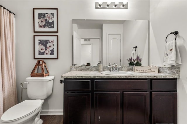 bathroom with hardwood / wood-style floors, vanity, and toilet