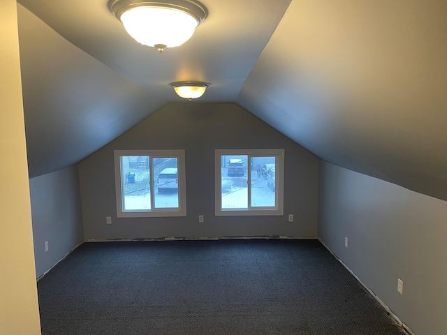 bonus room featuring dark colored carpet and vaulted ceiling