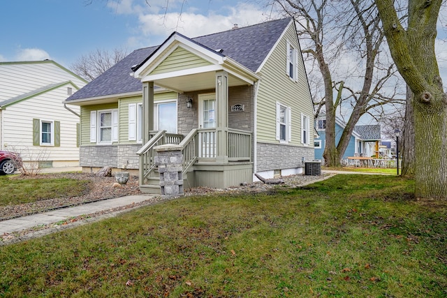 view of front of house with central air condition unit and a front yard