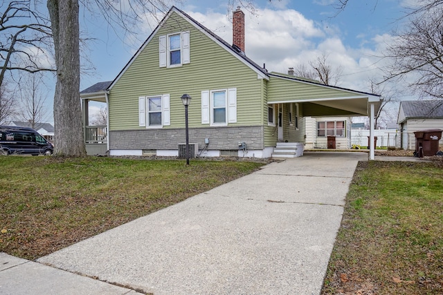 view of front of home with central AC, a front yard, and a carport