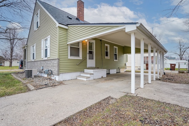 view of front of property with central AC and a carport