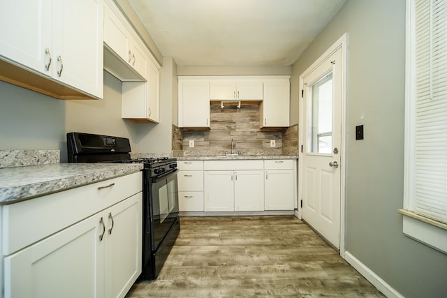 kitchen with black range with gas stovetop and white cabinetry