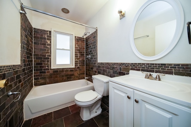 full bathroom with tiled shower / bath, vanity, toilet, and tile walls