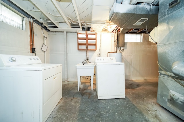 laundry room with washer and clothes dryer, heating unit, sink, and water heater