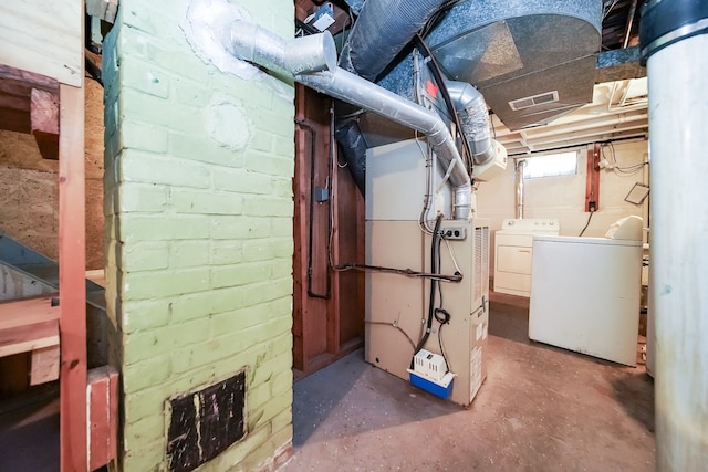 basement featuring washing machine and clothes dryer and heating unit