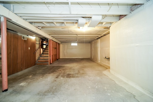 basement featuring wooden walls