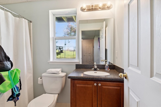 bathroom with toilet, curtained shower, and vanity