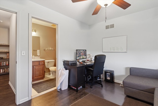 office with dark wood-type flooring, visible vents, baseboards, and a ceiling fan