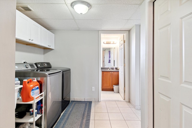 laundry room featuring cabinet space, light tile patterned floors, baseboards, visible vents, and independent washer and dryer