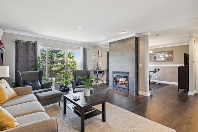 living room featuring recessed lighting, wood finished floors, baseboards, ornamental molding, and a tiled fireplace