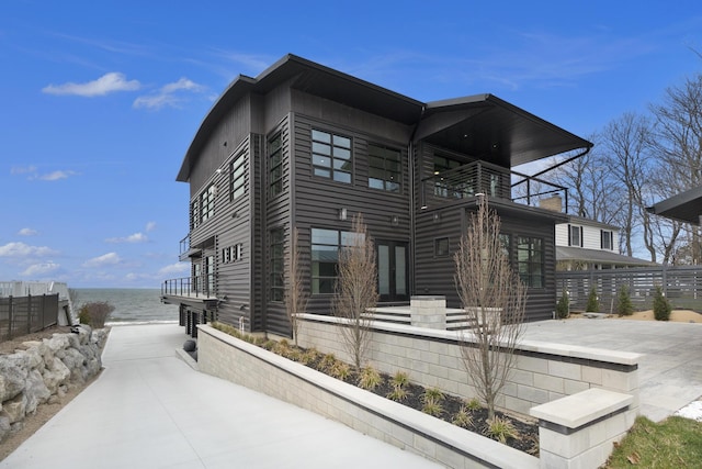 view of property exterior with a balcony and a water view