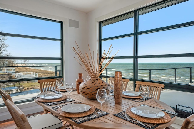 dining space with a water view and wood-type flooring