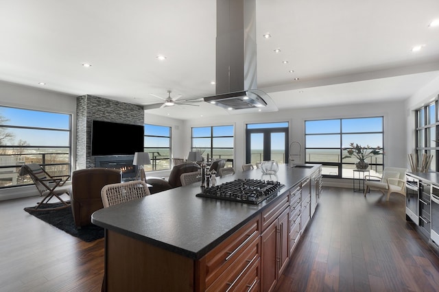 kitchen with a kitchen island with sink, a wealth of natural light, and stainless steel gas stovetop