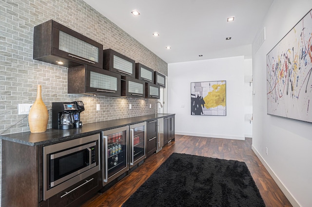 bar featuring dark hardwood / wood-style flooring, stainless steel microwave, backsplash, and wine cooler