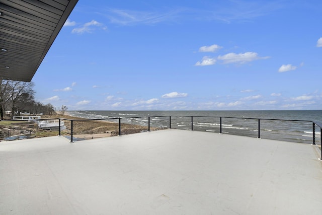 view of patio with a water view and a beach view