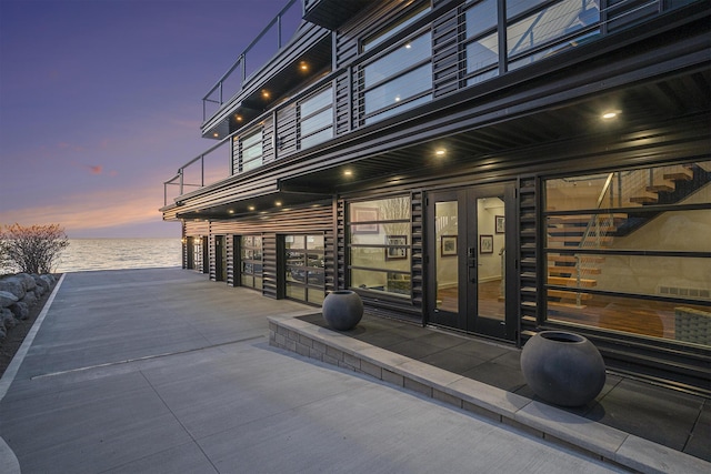 exterior space with french doors and a water view