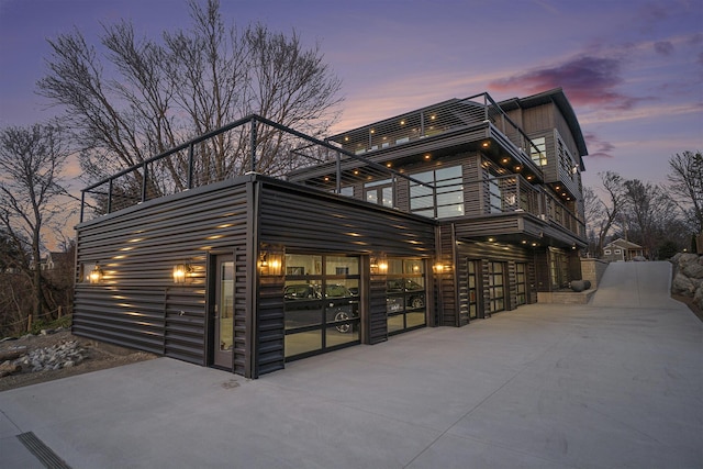 property exterior at dusk featuring a balcony