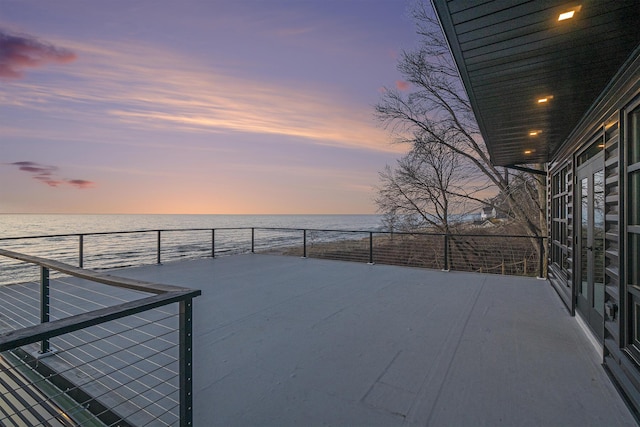 patio terrace at dusk featuring a water view