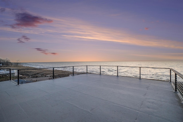 patio terrace at dusk featuring a water view