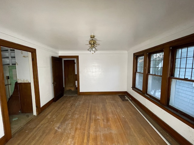 unfurnished room featuring hardwood / wood-style floors, ceiling fan, and crown molding