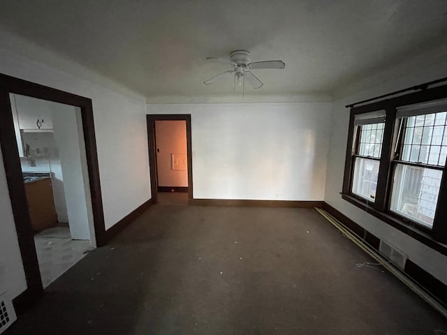 unfurnished room with ceiling fan and concrete floors