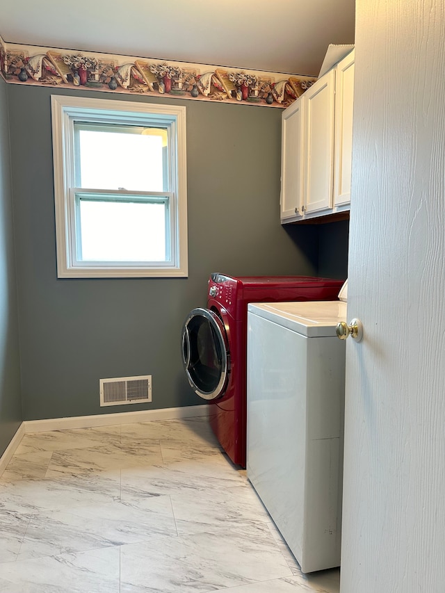 laundry room with washer and dryer and cabinets