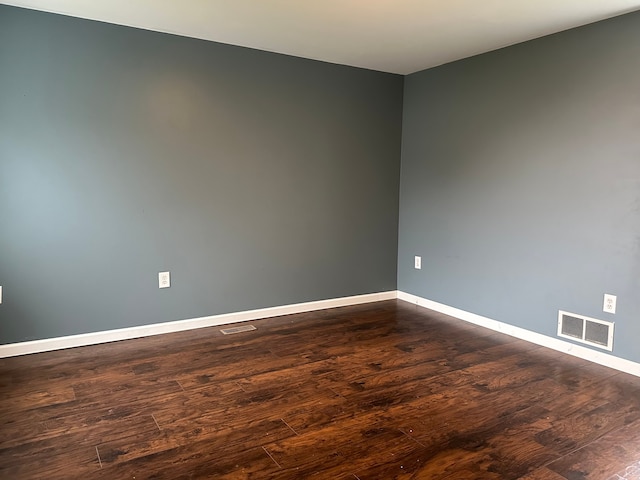 unfurnished room with dark hardwood / wood-style flooring