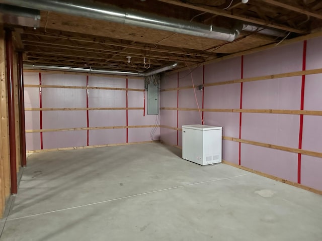 basement featuring electric panel and refrigerator