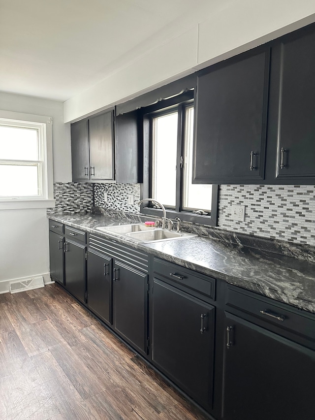 kitchen featuring sink, decorative backsplash, and dark wood-type flooring