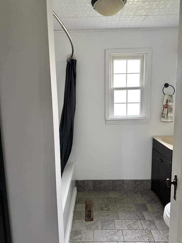 full bathroom featuring toilet, shower / bath combo with shower curtain, and vanity