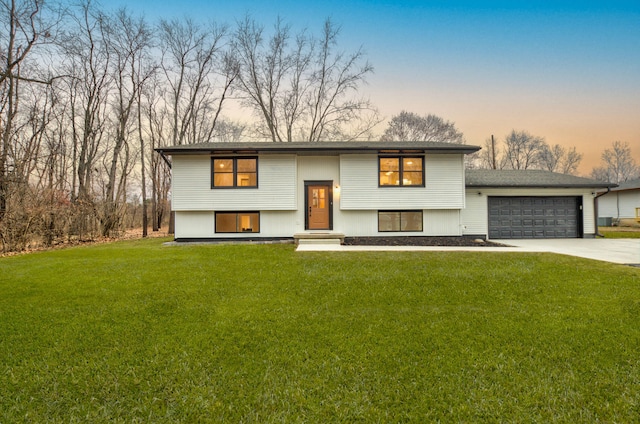 raised ranch with a lawn and a garage