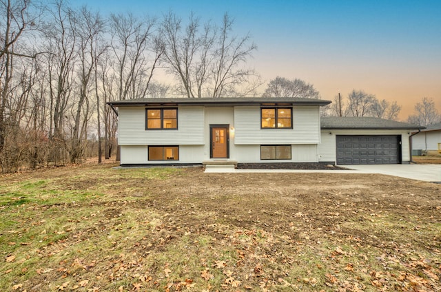 bi-level home with a garage and a yard