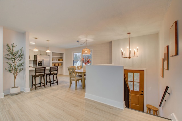 foyer entrance featuring light hardwood / wood-style floors and an inviting chandelier