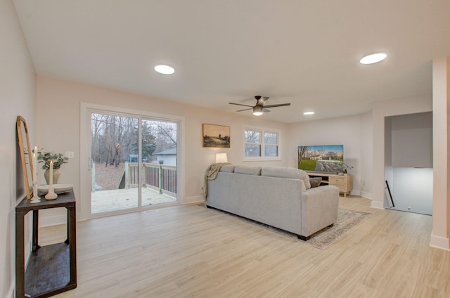 living room with light hardwood / wood-style floors, plenty of natural light, and ceiling fan