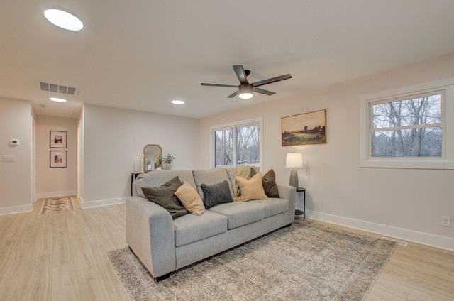 living room with light hardwood / wood-style flooring and ceiling fan