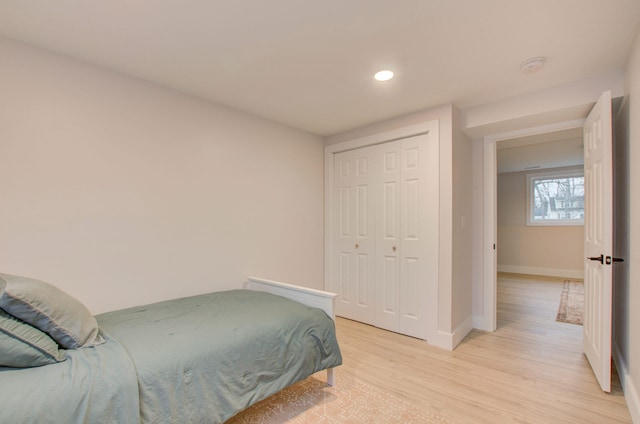 bedroom with light hardwood / wood-style floors and a closet