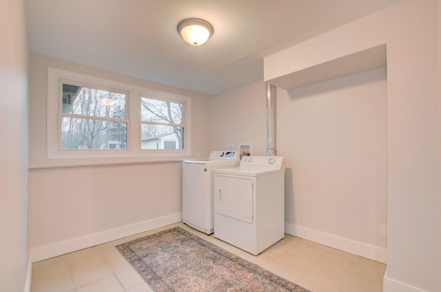 clothes washing area featuring light tile patterned floors and washing machine and clothes dryer