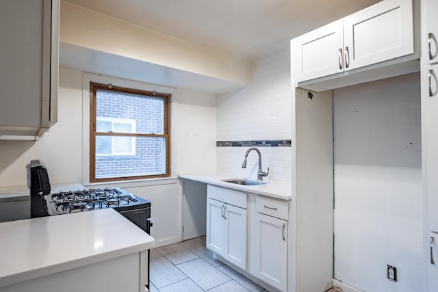 kitchen featuring sink, white cabinetry, and backsplash