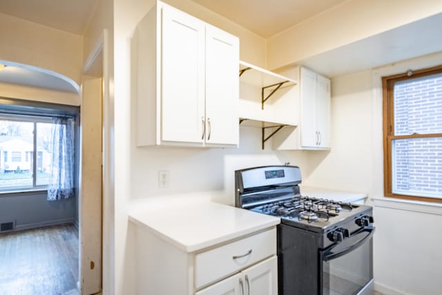 kitchen featuring hardwood / wood-style floors, white cabinets, and range with gas cooktop