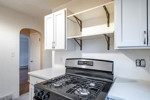 kitchen with gas stove, light hardwood / wood-style floors, and white cabinetry