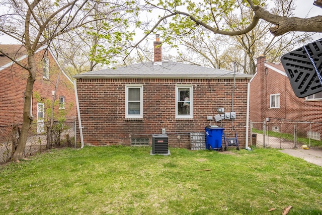 back of house with a lawn and central air condition unit