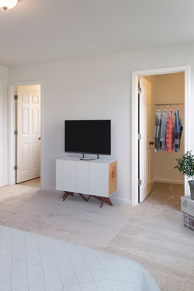 carpeted bedroom featuring a closet and a walk in closet