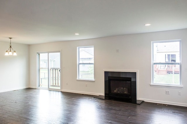 unfurnished living room featuring dark hardwood / wood-style floors and a chandelier