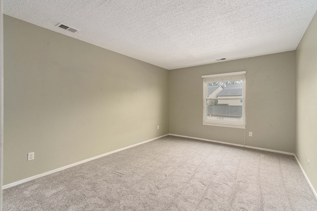 carpeted empty room with a textured ceiling