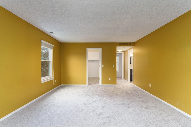 unfurnished room featuring carpet floors and a textured ceiling