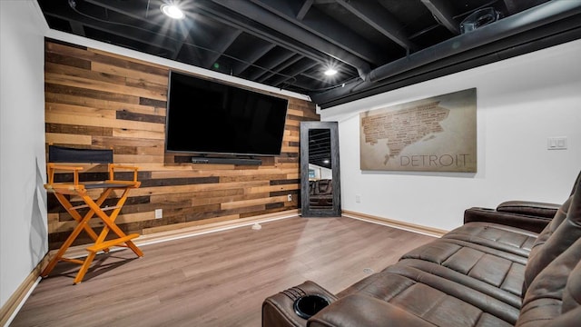 cinema room featuring hardwood / wood-style floors and wooden walls