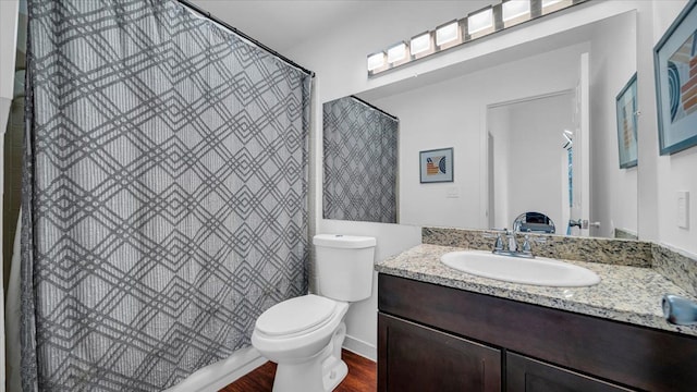 bathroom featuring hardwood / wood-style floors, vanity, toilet, and walk in shower